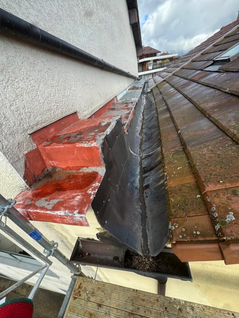 Noue zinc à nettoyer à la jonction mur et toiture