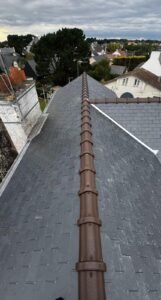 Toiture en ardoise neuve avec faîtage en tuiles faîtières
